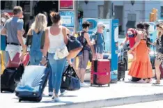  ??  ?? Turistas esperan el bus en una parada de Barcelona.