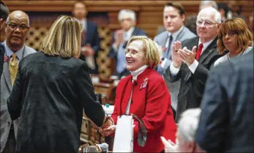  ?? BOB ANDRES / ROBERT.ANDRES@AJC.COM ?? Rep. Sharon Cooper, R-Marietta, receives a standing ovation and is congratula­ted by Speaker Pro Tem Jan Jones, R-Milton, after the House passed HB 987 to increase measures for the protection of elderly persons in senior care facilities.
