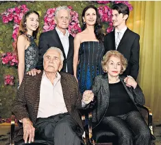  ??  ?? Left, Catherine Zeta-Jones serenades her father-in-law. Above, Kirk Douglas with wife Anne, son Michael, Zeta-Jones and grandchild­ren. Right, the birthday cake is finished, and below, Kirk Douglas as Spartacus