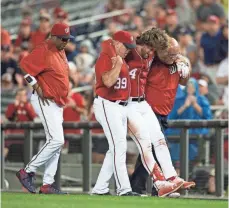  ??  ?? Manager Dusty Baker, left, watches as Harper is helped off the field. An MRI showed he suffered a significan­t bone bruise.