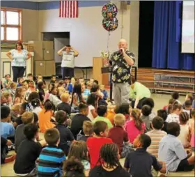  ?? MICHILEA PATTERSON — DIGITAL FIRST MEDIA ?? Franklin Elementary School Principal Kevin Downes shows an auditorium room full of students the Wellness Checklist Achievemen­t Award they received this year for implementi­ng healthy programs.