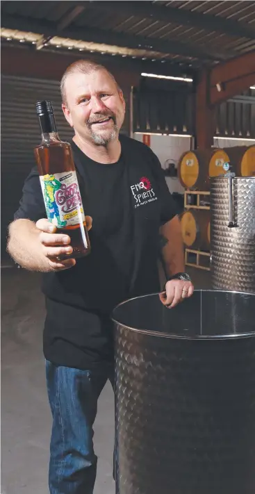  ?? Picture: BRENDAN RADKE ?? HIGH SPIRITS: Distiller Troy Read, with a bottle of his Croc Piss liqueur, has moved FNQ Spirits into a larger warehouse at Cairns North to keep up with demand.