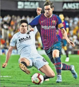  ?? AFP ?? Valencia midfielder Carlos Soler tackles Barcelona's Lionel Messi during their match on Sunday.