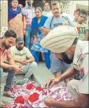  ??  ?? Police officials near the body of the RSS leader Ravinder Gosain (right) after he was gunned down outside his house in Ludhiana on Tuesday. See also, P2 GURPREET SINGH/HT