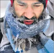  ?? AP ?? Icicles hang from Jeffery Hemmer's beard as he walks near his home in Fairview, Illinois.