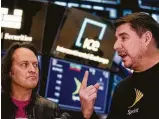  ?? Michael Nagle / Bloomberg ?? John Legere, T-Mobile US CEO, left, listens as Marcelo Claure, CEO of Sprint Corp., is interviewe­d Monday in New York.