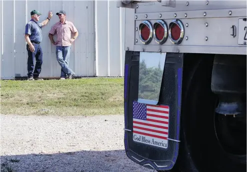  ?? NATI HARNIK / THE ASSOCIATED PRESS FILES ?? Farmer Don Bloss, left, talks to his son Mark behind a grain truck on his farm in Pawnee City, Neb. Despite what U.S. President Donald Trump says, most of the U.S, farm sector has done very well in trade with Canada.