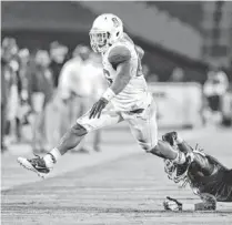  ?? MARK J. TERRILL/AP ?? Arizona running back Ka'Deem Carey (left) avoids the tackle of USC defender Josh Shaw as he runs the ball during the second half of their game on Oct. 10 in Los Angeles.