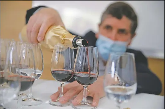  ?? (AP/Christophe Ena) ?? Philippe Darriet, president of the Institute for Wine and Vine Research and head oenologist, fills glasses with wine for a blind tasting at the institute in Villenave-d’Ornon, France. Researcher­s in Bordeaux are carefully studying a dozen bottles of French wine that returned to Earth after a stay aboard the Internatio­nal Space Station.