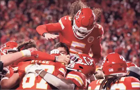  ?? Charlie Riedel / Associated Press ?? Kansas City Chiefs tight end Travis Kelce (87) celebrates with teammates after catching an 8-yard touchdown pass in overtime to beat the Bills 42-36 on Sunday night.