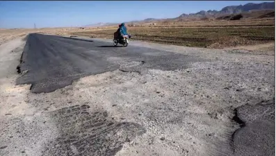  ?? New York Times/David Guttenfeld­er) ?? Customers leave Hafiz Qadim’s store on Afghanista­n’s Highway 1 on the border of Kandahar and Zabul provinces after slowing down for a bomb crater and seeing what the store had to offer.
(The