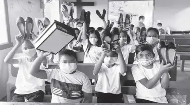  ?? ?? Children beneficiar­ies show off their new shoes. More than 100,000 pairs of shoes were gifted by The SM Store and SM Foundation to Caritas Philippine­s communitie­s nationwide.