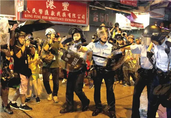 ?? — Reuters photos ?? Riot police point their guns towards demonstrat­ors during Sunday night’s clashes.