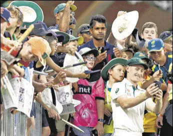  ?? GETTY ?? Marnus Labuschagn­e takes selfies with fans after Australia’s win over New Zealand in Perth.