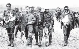  ?? REUTERS ?? British soldiers wounded in the trenches on the Western Front during World War 1 make their way back from the front line.