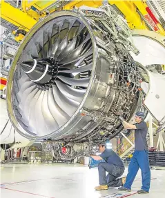  ??  ?? Technician­s work on a Rolls-royce Trent XWB engine.