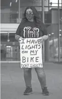  ?? MEG POTTER/THE REPUBLIC ?? Eva Cano, Anthony Cano’s aunt, holds a sign that reads “I have lights on my bike, don't shoot” at Chandler City Hall on Feb. 22.