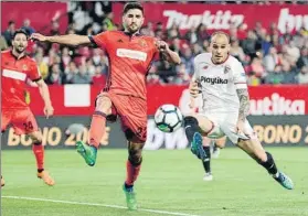  ?? FOTO: EFE ?? Raúl Navas se anticipa a Sandro para cortar un envío sobre el delantero del Sevilla