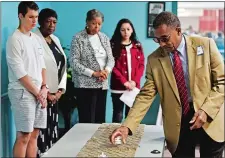  ?? SEAN D. ELLIOT/THE DAY ?? Lonnie Braxton, right, places an electronic candle on the table during the culminatio­n of the Encounteri­ng Difference­s program Thursday at East Lyme High School. Students from East Lyme, Plainfield and Norwich participat­ed in the pilot program...