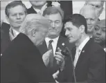  ?? MANUEL BALCE CENETA / AP ?? As Sen. Dean Heller, R-nev., (center) applauds behind them, President Donald Trump shakes hands with House Speaker Paul Ryan, R- Wis., during an event Wednesday at the White House to acknowledg­e the final passage of tax overhaul legislatio­n by Congress.