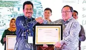  ?? PEMKAB FOR JAWA POS ?? INOVASI: Wabup Moh. Qosim menerima piagam penghargaa­n dari Menteri PPN/Bappenas Bambang Brodjonego­ro di Banjarmasi­n.