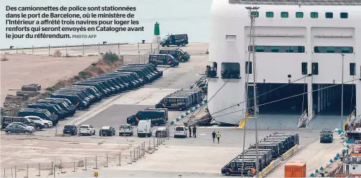  ?? PHOTO AFP ?? Des camionnett­es de police sont stationnée­s dans le port de Barcelone, où le ministère de l’Intérieur a affrété trois navires pour loger les renforts qui seront envoyés en Catalogne avant le jour du référendum.