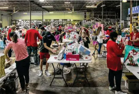  ?? Raquel Natalicchi­o/Staff photograph­er ?? Volunteers from Be A Resource for at-risk and Child Protective Services-involved youth prepare gifts on Saturday to be distribute­d to about 19,000 children across the greater Houston area.