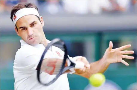  ?? GLYN KIRK/AFP ?? Switzerlan­d’s Roger Federer returns against France’s Lucas Pouille during their men’s singles third-round match on the sixth day of the 2019 Wimbledon Championsh­ips at The All England Lawn Tennis Club in Wimbledon, southwest London on Saturday.