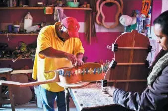  ?? RONALDO SCHEMIDT / AGENCE FRANCE-PRESSE ?? Mexican luthier Salvador Meza (left) Mexico on Tuesday. and his wife, make a replica guitar from at their workshop, in Paracho, Michoacan state,