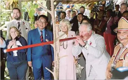  ?? PIC BY NADIM BOKHARI ?? Prince Charles getting a feel of the Penan blowpipe at the Sarawak Culture Village in Santubong yesterday. With him is his wife, Camilla.