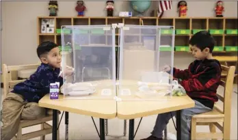  ?? ASHLEE REZIN GARCIA/CHICAGO SUN-TIMES VIA AP, POOL ?? In this Jan. 11, 2021, file photo, preschool students eat lunch at Dawes Elementary in Chicago. Pressure is building on school systems around the U.S. to reopen classrooms to students who have been learning online for nearly a year, pitting politician­s against teachers who have yet to be vaccinated against COVID-19.