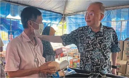  ?? — Picture taken from dr Wee’s Facebook page ?? Friendly chat: dr Wee greeting a local at the #Keluargama­laysia Sale in yong Peng.