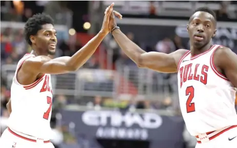  ?? | ALEX BRANDON/ AP ?? Justin Holiday ( left), Jerian Grant and the rest of the Bulls have not been following the tanking master plan this season.