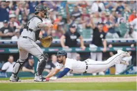  ?? AP PHOTO/PAUL SANCYA ?? Detroit Tigers' Riley Greene slides safely into home plate to score Sunday as Chicago White Sox catcher Yasmani Grandal (24) waits for the throw in the ninth inning of a baseball game in Detroit.