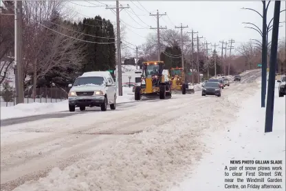  ?? NEWS PHOTO GILLIAN SLADE ?? A pair of snow plows work to clear First Street SW, near the Windmill Garden Centre, on Friday afternoon.