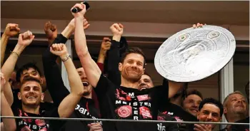  ?? — AFP photo ?? Alonso (centre) celebrates with a mock-up of the Bundesliga trophy with his players after the German Bundesliga match Bayer 04 Leverkusen v Werder Bremen in Leverkusen, western Germany.