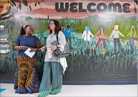  ?? PHOTOS BY SARAH GORDON/THE DAY ?? Speaker Sistah Anyango, left, with the FLYY Movement, and Steering Committee member Elizabeth Rougny speak Sunday following a mural reveal ceremony for Public Art for Racial Justice Education’s Sister Mural at Lyme-Old Lyme Middle School. The mural is part of the nonprofit PARJE’s Sister Mural project to bring together towns in southeaste­rn Connecticu­t through art and community.