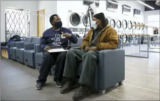  ?? TERESA CRAWFORD — THE ASSOCIATED PRESS ?? Herman Simmons, left, makes a vaccinatio­n appointmen­t for Theopulis Polk at a Chicago laundromat on March 6. U.S. communitie­s are working to overcome mistrust and improve access among people of color.