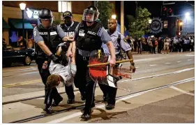  ?? JEFF ROBERSON / ASSOCIATED PRESS ?? Police arrest a man as they try to clear a violent crowd on Saturday in University City, Mo. Earlier, protesters marched peacefully in response to a not guilty verdict in the trial of former St. Louis police officer Jason Stockley.