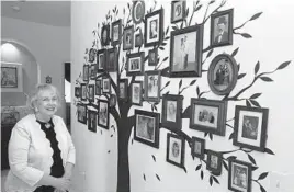  ?? JOHN RAOUX/AP ?? Elaine Powell, president of the Central Florida Genealogic­al Society, is seen with photos of her family tree this week at her home in Orlando, Florida.
