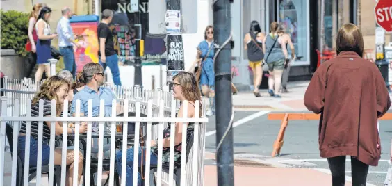  ?? KEITH GOSSE • THETELEGRA­M ?? Water Street in St. John’s appeared a little busier Thursday after the province went to Alert Level 2. Diners and pedestrian­s took advantage of the sun and warm weather to stroll the downtown and eat at some of the restaurant­s, including ones with outdoor patios.