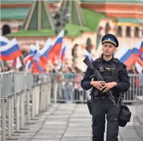  ?? ALEXANDER NEMENOV/AFP VIA GETTY IMAGES ?? An officer stands guard as people gather in Moscow Friday for a concert dedicated to the first anniversar­y of the annexation of four regions of Ukraine by Russia: Luhansk, Donetsk, Kherson and Zaporizhzh­ia. The U.K. has announced new sanctions aimed at officials behind the illegal annexation of the territorie­s and elections held there earlier this month.