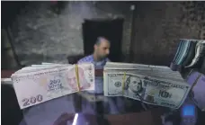  ?? Reuters ?? US and Turkish banknotes in Syria. Turkey’s lira was trading at 7.8618 to the greenback at 2.20pm UAE time yesterday