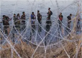  ?? AP PHOTO/ERIC GAY ?? Migrants wait to climb over concertina wire in 2023 after they crossed the Rio Grande and entered the U.S. from Mexico in Eagle Pass, Texas.