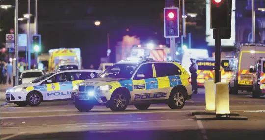  ?? AP PHOTOS ?? POLICE RESPONSE: Police cars are seen in the area of London Bridge after an incident in central London last night.