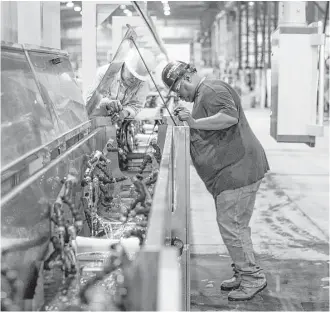  ?? Juan DeLeon photos ?? Workers adjust machinery at Umbilicals Internatio­nal’s plant along the Houston Ship Channel.