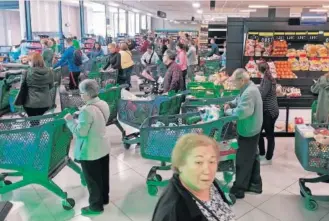  ?? EFE ?? Decenas de personas hacen cola ante las cajas de un supermerca­do en Murcia a primera hora de la mañana del viernes.