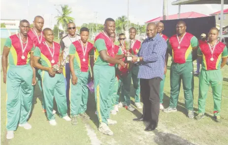  ??  ?? The Guyana Defence Force skipper Leon Andrews (left center) receives the Balram Raghubir InterServi­ce T/20 championsh­ip trophy.