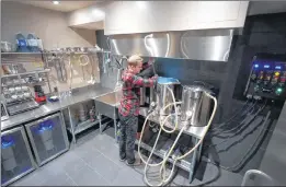  ??  ?? In this 2013 photo provided by Kal Wallner, Wallner looks over his kettles in his home brewery room in Ottawa, Canada. Wallner is an electrical engineer who designed a brewing system for himself that he now sells online at Theelectri­cbrewery.com.