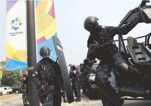  ?? REUTERS ?? An Indonesia Kopassus special forces soldier jumps from a car after an anti-terror drill ahead of the upcoming Asian Games in Jakarta, Indonesia.